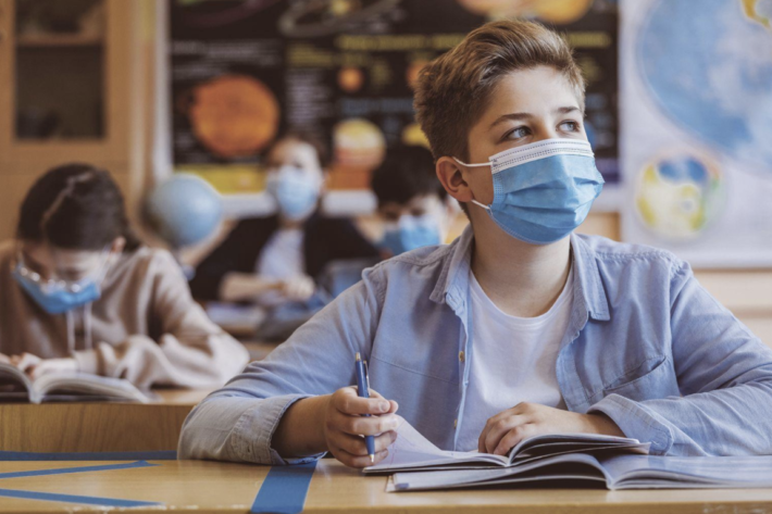 Student studying while wearing a surgical mask